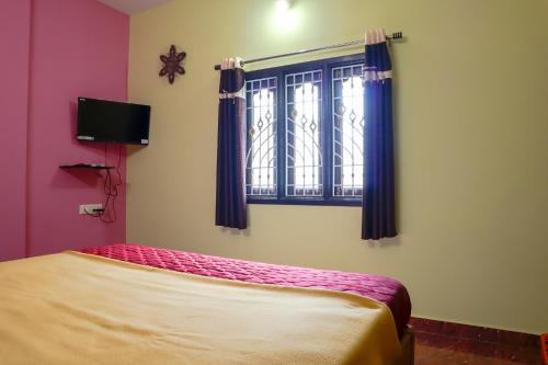 a bedroom with a bed and a window at Lakeside Home Stay Villa in Yelagiri