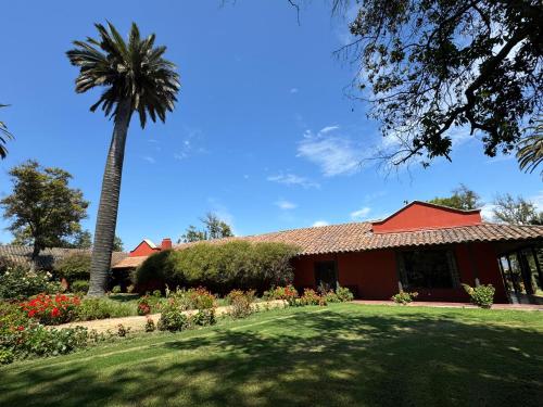 a house with a palm tree and a yard at Casona Lo Aguirre , Hospedaje de Temporada Cálidas in Talagante