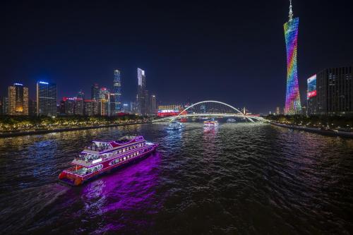 a boat in the water with a city at night at Yushe High-altitude Night View Hotel-Guangzhou Tower Zhujiang New Town Branch Exclusive for the Canton Fair in Guangzhou