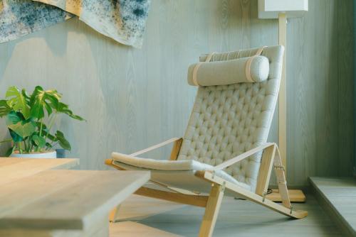 a rocking chair in a room with a table at HOTEL & KOTEI SOKA in Kyotango