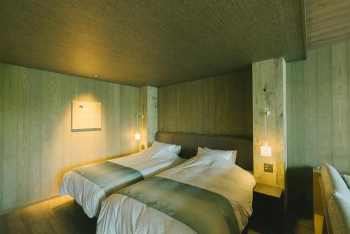 a bedroom with a large bed and two lamps at HOTEL & KOTEI SOKA in Kyotango