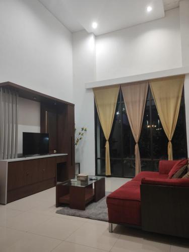 a living room with a red couch and a tv at Cheery Home Surabaya 10 mins toll near Pakuwon Mall in Surabaya