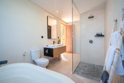 a bathroom with a toilet and a sink and a shower at Villa Biku in Umalas
