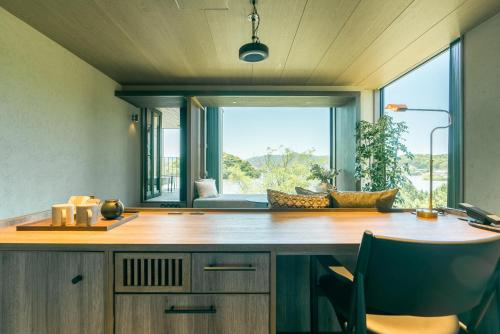 a kitchen with a counter and a large window at HOTEL & KOTEI SOKA in Kyotango