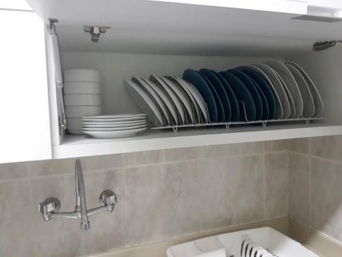 a bathroom with a sink and plates on a shelf at Apartamento en malecón de Salinas hermosa vista in Salinas