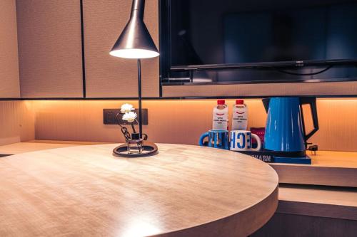 a lamp sitting on top of a wooden table at Echarm Hotel Fujian Hongtuo Central City in Tengcheng