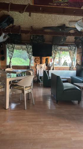 a living room with couches and tables and chairs at Brvnara Ruza Rumena in Mionica
