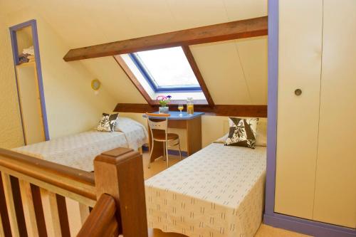 a attic room with two beds and a table at VTF Le Sénéquet in Blainville-sur-Mer
