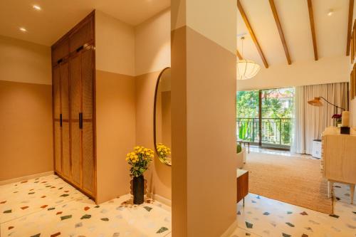 a hallway with a door and a vase of flowers at ELIVAAS 4 BHK with Pvt Pool - Amado Villa Euphoria in Assagao