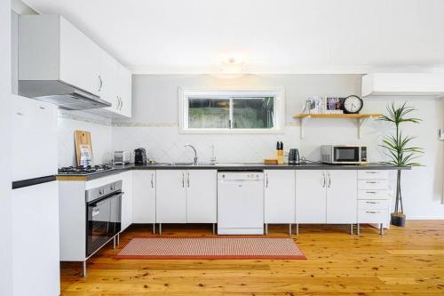 a kitchen with white cabinets and a counter top at 3B3B w Farm View w Outdoor Dining,Shared Game Room in Bilpin