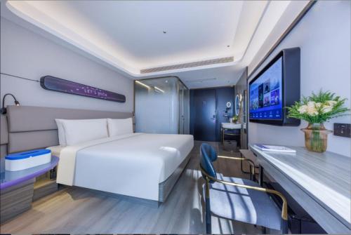 Un dormitorio con una cama blanca y un televisor. en Atour X Hotel Shanghai Lujiazui Lancun Road, en Shanghái