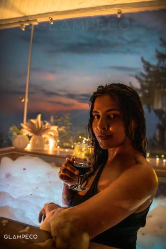 a woman is holding a glass of wine at GlampEco Manali in Manāli
