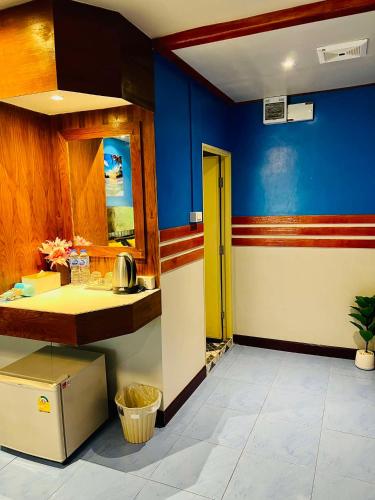 a kitchen with blue walls and a yellow door at Mom Boutique Railay in Railay Beach