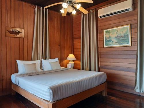 a bedroom with a bed with wood paneling at Samui Wooden Hill Resort in Lamai