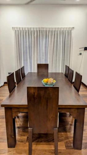 a table with chairs and a bowl of fruit on it at TJ Villa in Seeduwa