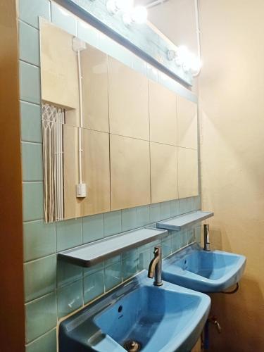 a bathroom with two blue sinks and a mirror at Be Local BNB in Bangkok