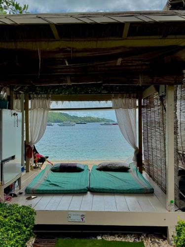 two beds on a porch with a view of the ocean at Mama Beach Residence - Adults Only in Phi Phi Don