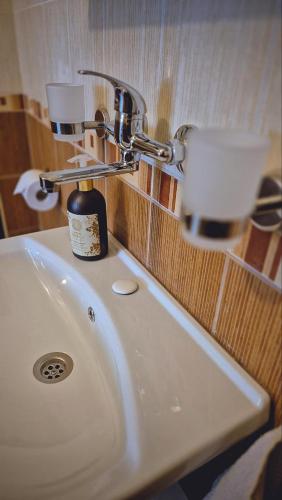 a bathroom sink with a cup on top of it at Lavender Lodge Tsarichino in Tsarichino