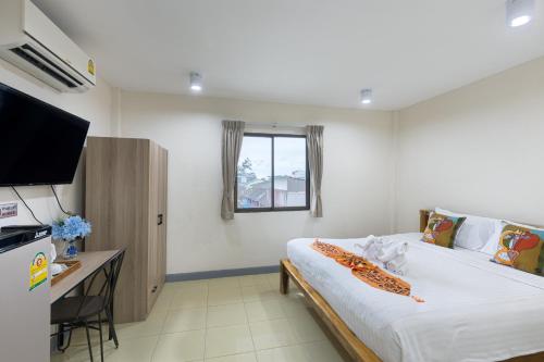 a bedroom with a bed and a desk and a television at PMS Boutique Patong in Patong Beach