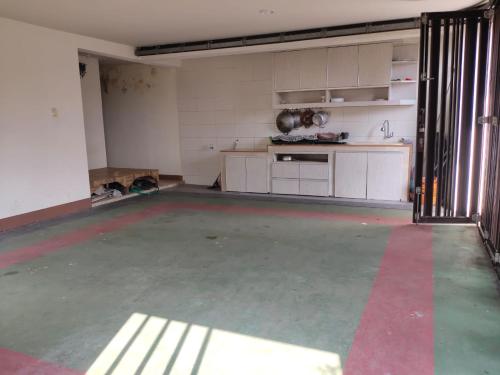 an empty room with a kitchen with a red stripe on the floor at Veladiena - Vimala Hills in Gadok 1