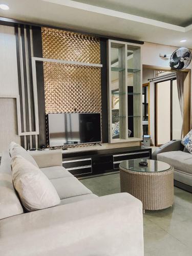 a living room with a white couch and a tv at Veladiena - Vimala Hills in Gadok 1