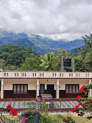 a white building with mountains in the background at Luna Munnar 4Bedroom Villa in Anachal