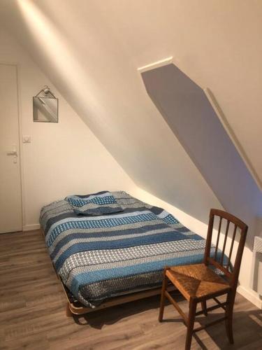 - une chambre avec un lit et un fauteuil en bois dans l'établissement Grande maison avec piscine, à Limoise