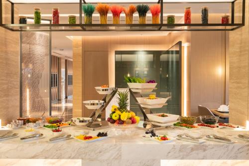 a buffet line with plates of food on a table at Boudl Al Rawdah in Buraydah