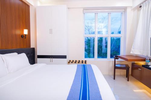 a bedroom with a bed and a desk and a window at Le Dream Hotel near Vigan in Anomang Mayor