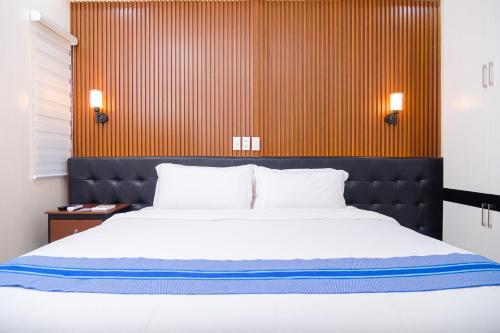 a bedroom with a large bed and a wooden wall at Le Dream Hotel near Vigan in Anomang Mayor