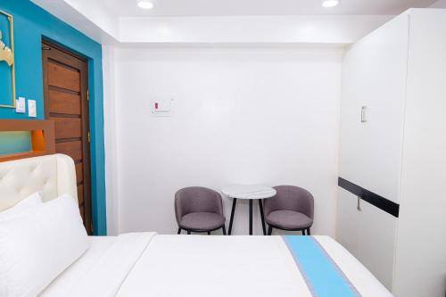 a bedroom with a bed and two chairs at Le Dream Hotel near Vigan in Anomang Mayor