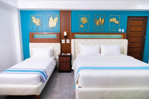 two beds in a room with blue walls at Le Dream Hotel near Vigan in Anomang Mayor