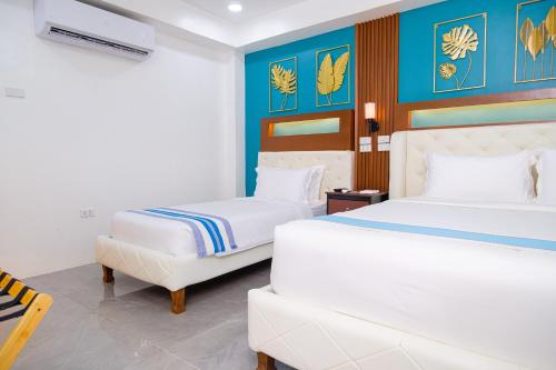 a bedroom with two beds and a couch at Le Dream Hotel near Vigan in Anomang Mayor