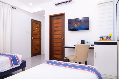 a bedroom with a bed and a desk with a computer at Le Dream Hotel near Vigan in Anomang Mayor
