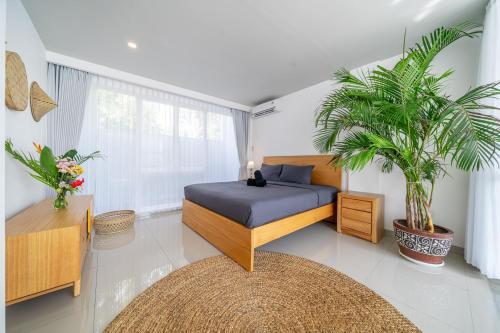ein Schlafzimmer mit einem Bett und zwei Topfpflanzen in der Unterkunft The View Villa 10 - 2br Cozy Loft in Uluwatu in Uluwatu