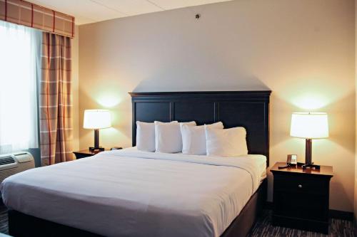a hotel room with a large bed with two lamps at Country Inn & Suites by Radisson, Frackville (Pottsville), PA in Mount Pleasant