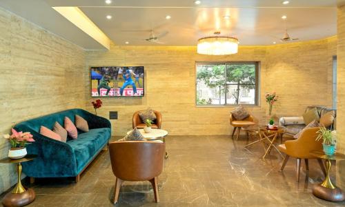 a living room with a green couch and chairs at Hotel Maharaja Regency in Satara