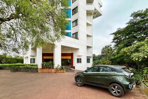 a green car parked in front of a building at Hotel Maharaja Regency in Satara
