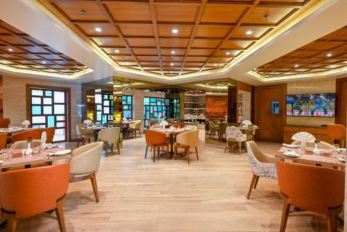 a restaurant with tables and chairs in a room at Hotel Maharaja Regency in Satara