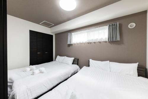 zwei Betten mit ausgestopften Tieren in einem Schlafzimmer in der Unterkunft Essence in Sapporo