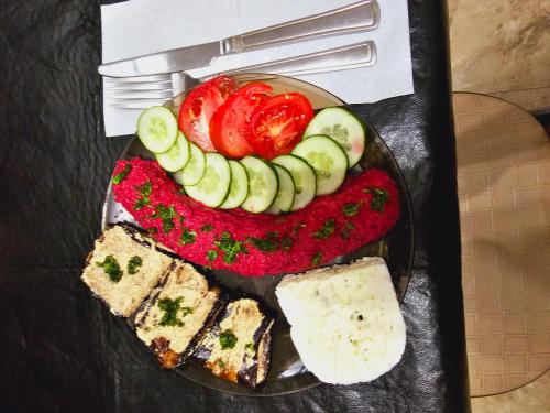 a plate of food with tomatoes cucumbers and cheese at Guesthouse different in Tbilisi City