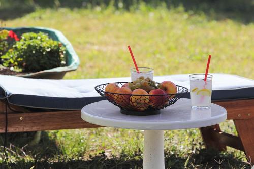 a bowl of fruit on a table with two drinks at Vila Mozara in Slano