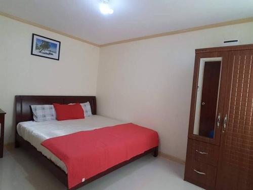 a bedroom with a bed with a red blanket and a cabinet at 2 Storey house, 2BR, 2CR Fully Furnished house in Consolacion