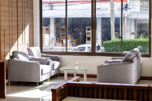 a room with two chairs and a table and windows at The President Hotel at Chokchai 4 in Bangkok