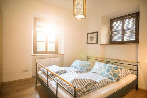 a bed with two pillows on it in a room at Ferienwohnung Altes Schulhaus Greising in Deggendorf