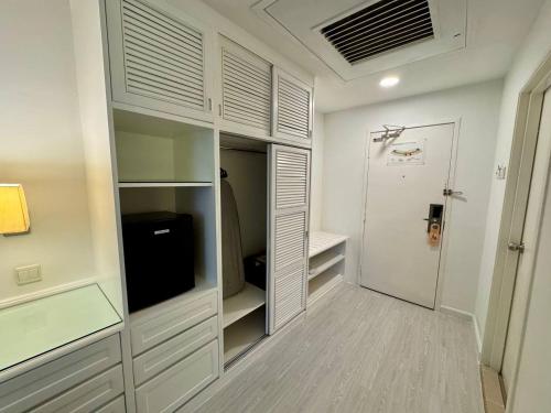 a walk in closet with white cabinets and a television at ROYAL PARK HOTEL @ UNITEN in Kajang
