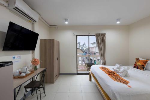 a bedroom with a bed and a desk and a television at PMS Boutique Patong in Patong Beach