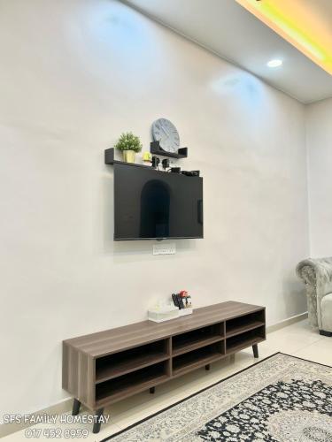 a living room with a tv on a white wall at SFS Family Homestay Kulim in Kulim