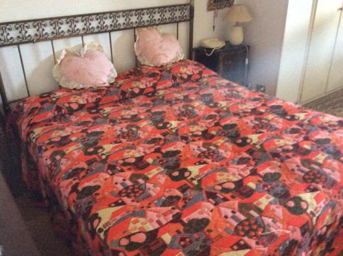 a bed with a comforter and two pillows on it at Villa Nanda a 15 minuti da Roma piscina esclusiva , villa nella natura in Formello