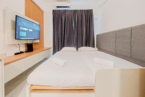ein Schlafzimmer mit zwei Betten und einem Flachbildfernseher in der Unterkunft Cozy Living Studio Sky House BSD Apartment near AEON Mall By Travelio in Tangerang